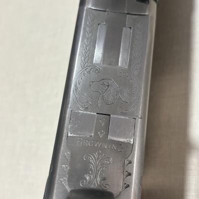 Parte metálica de arma Browning com gravura e texto