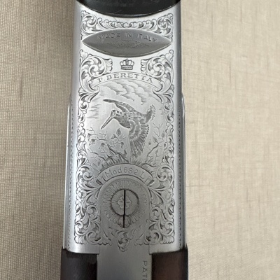 Detalhe metálico gravado em arma com textos MADE IN ITALY e P. BERETTA