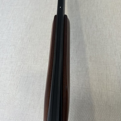 Espingarda com coronha de madeira castanha e cano preto vista de cima