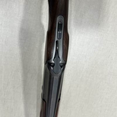 Carabina de caça com coronha em madeira castanho escuro e detalhes metálicos cinzentos