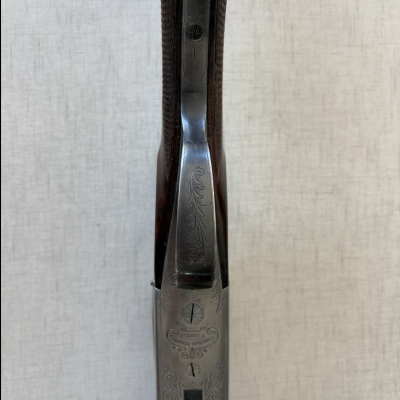 Parte superior de uma arma de fogo com metal decorado e texto gravado