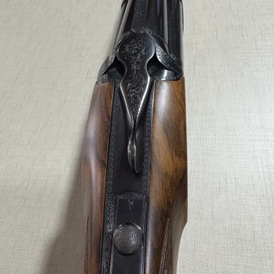 Arma de fogo de canos duplos com coronha em madeira e detalhes gravados