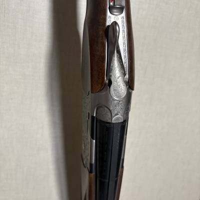 Arma de caça com coronha em madeira e partes metálicas prateadas decoradas