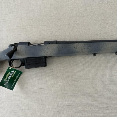 Carabina com coronha cinzenta e cano preto mate sobre fundo cinza claro