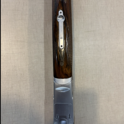 Pormenor de arma com punho em madeira e metal prateado