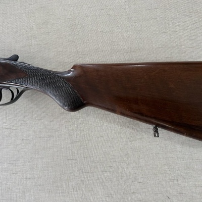 Espingarda com coronha em madeira castanha polida e empunhadura texturizada