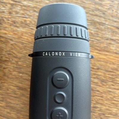 Dispositivo óptico preto com botões e texto CALONOX VIEW