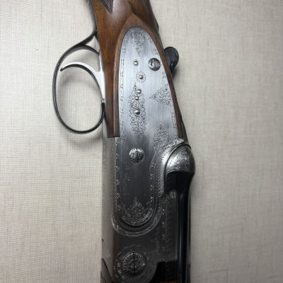 Espingarda em madeira e metal com detalhes gravados.