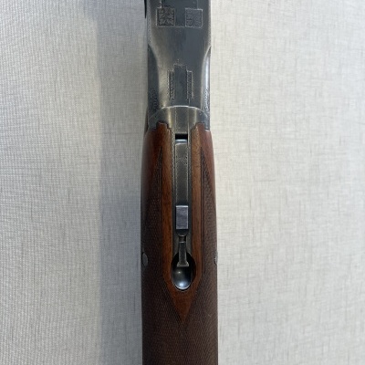 Espingarda com coronha em madeira e corpo metálico vista de cima