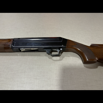 Espingarda com caixa preta e coronha de madeira castanha escura