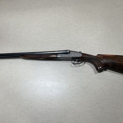 Espingarda de canos duplos em madeira e metal sobre fundo cinza