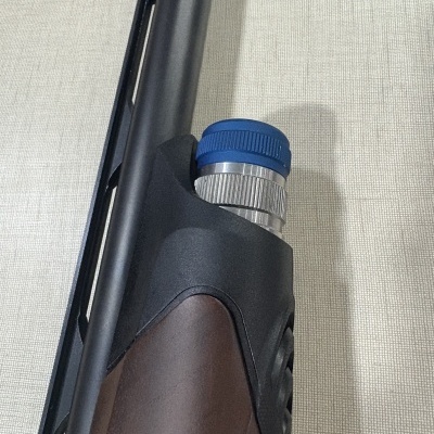 Arma de fogo com coronha castanha e peça metálica azul