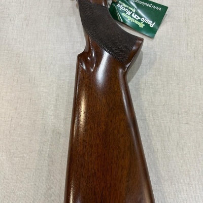 Coronha de espingarda em madeira polida com etiqueta verde da marca Paulo Emilio