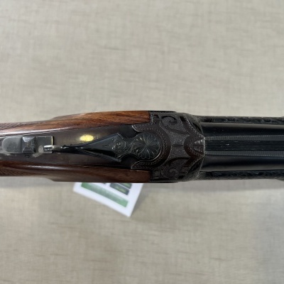 Espingarda de canos sobrepostos com madeira trabalhada e metal gravado