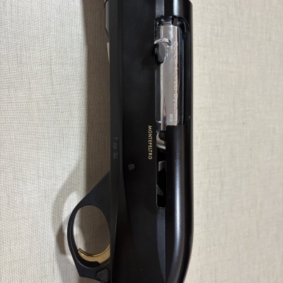 Espingarda Beretta Montefeltro com coronha de madeira e corpo metálico preto e prateado