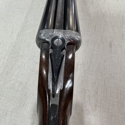 Espingarda de canos duplos com detalhes em madeira e metal gravado