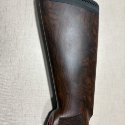 Espaçador de coronha de arma em madeira escura com acabamento polido e detalhes em plástico