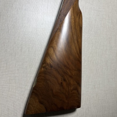 Coronha de arma de fogo em madeira castanha polida com padrão natural