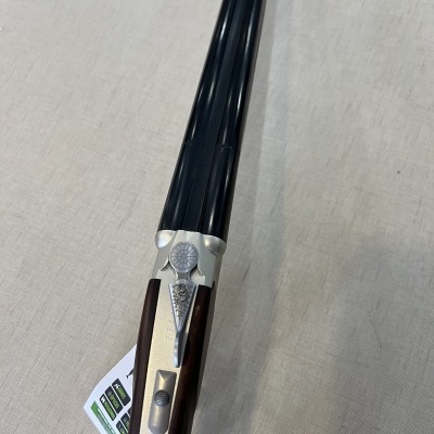 Espingarda de canos duplos com coronha de madeira sobre superfície clara