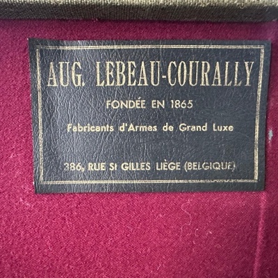 Etiqueta de couro preta com texto dourado sobre fundo vermelho