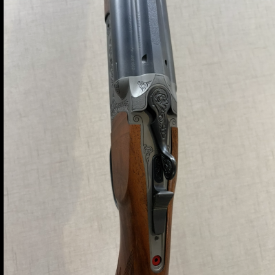 Espingarda de madeira e metal com detalhes entalhados e texto Blaser S/N 10782.