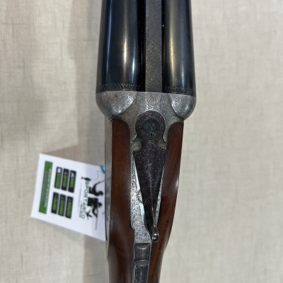 Espingarda de canos duplos com coronha em madeira e detalhes metálicos gravados