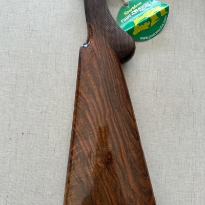 Coronha em madeira escura com etiqueta verde pendurada