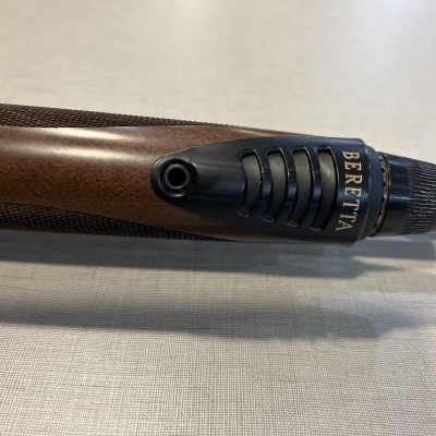 Cano de espingarda com coronha de madeira e detalhe preto com a palavra BERETTA