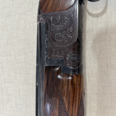 Espingarda de cano duplo com madeira escura e entalhes metálicos
