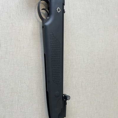 Espingarda preta com cabo sintético sobre fundo claro