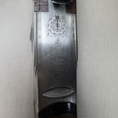 Parte superior de espingarda com metal gravado em prateado e madeira castanha