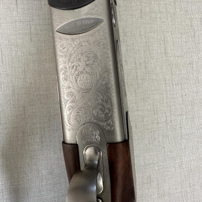 Parte de uma espingarda em madeira e metal gravado com texto 'MADE IN ITALY'