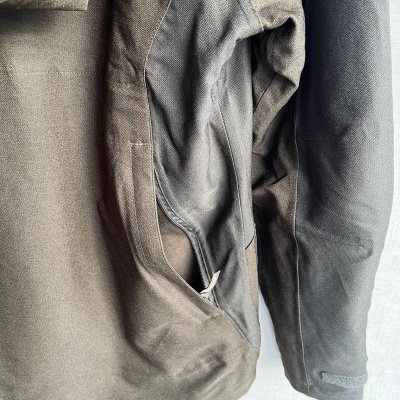 Casaco castanho e preto com mangas compridas em tecido misto, vista parcial