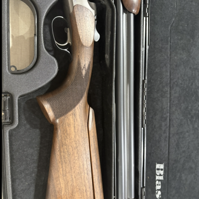 Espingarda com canos duplos e coronha em madeira numa mala preta com interior almofadado