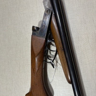 Espingarda de canos duplos em aço escuro e madeira trabalhada