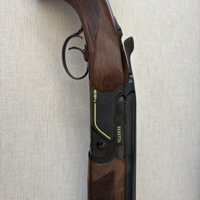 Espingarda de caça Beretta modelo 694 com madeira castanha e detalhes em amarelo.