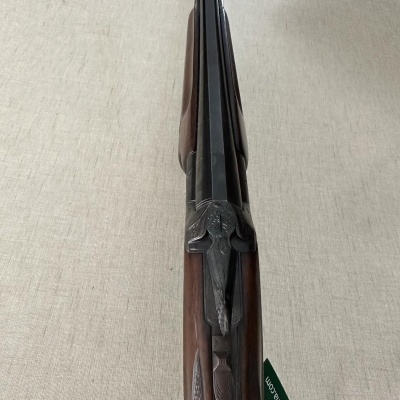 Espingarda de canos paralelos com coronha e cabo em madeira castanha e detalhes entalhados