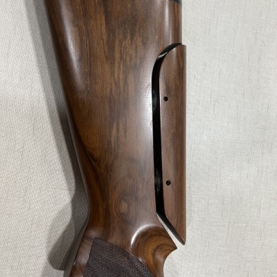 Coronha de carabina em madeira castanho-escura com borracha preta na ponta e textura antiderrapante.