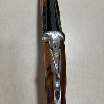 Espingarda de caça com detalhes em metal gravado e madeira polida