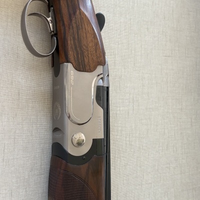 Espingarda com acabamento em madeira escura e metal prateado e preto mostrando a marca BERETTA e números 269