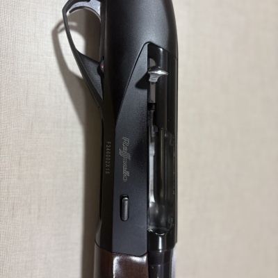 Espingarda Raffaello com coronha em madeira e corpo metálico preto