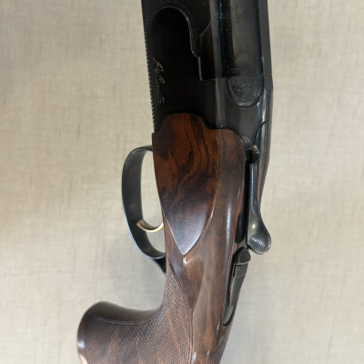 Espingarda com punho em madeira e corpo metálico preto gravado com a assinatura P. Beretta.