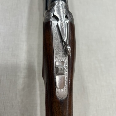 Espingarda de madeira e metal prateado vista de cima