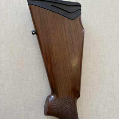 Coronha de arma de madeira castanha com acabamento em borracha preta.