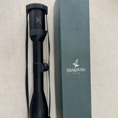 Luneta óptica preta ao lado de caixa verde com logotipo Swarovski Optik