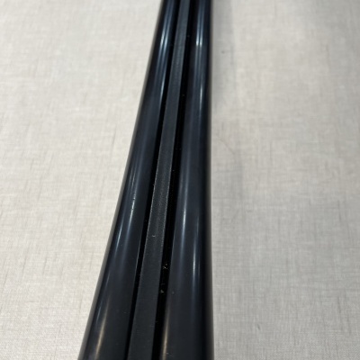 Três varetas pretas lisas com base cinzenta em tecido claro