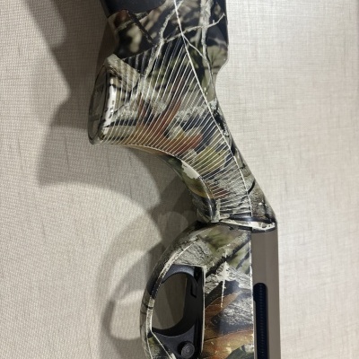 Coronha e empunhadura de arma com padrão camuflado verde, castanho e bege