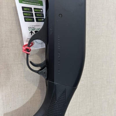 Arma preta com punho texturizado e etiqueta com informações