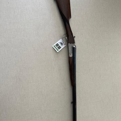 Espingarda de canos duplos com coronha em madeira e parte metálica gravada