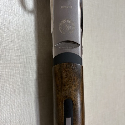 Caçadeira com coronha em madeira escura e marcações prateadas